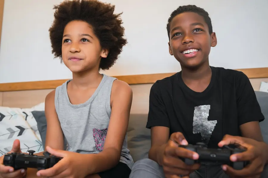 Two boys smiling while playing a video game together