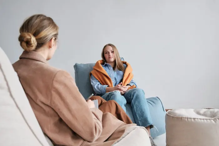 A practitioner talking with a young person on a sofa